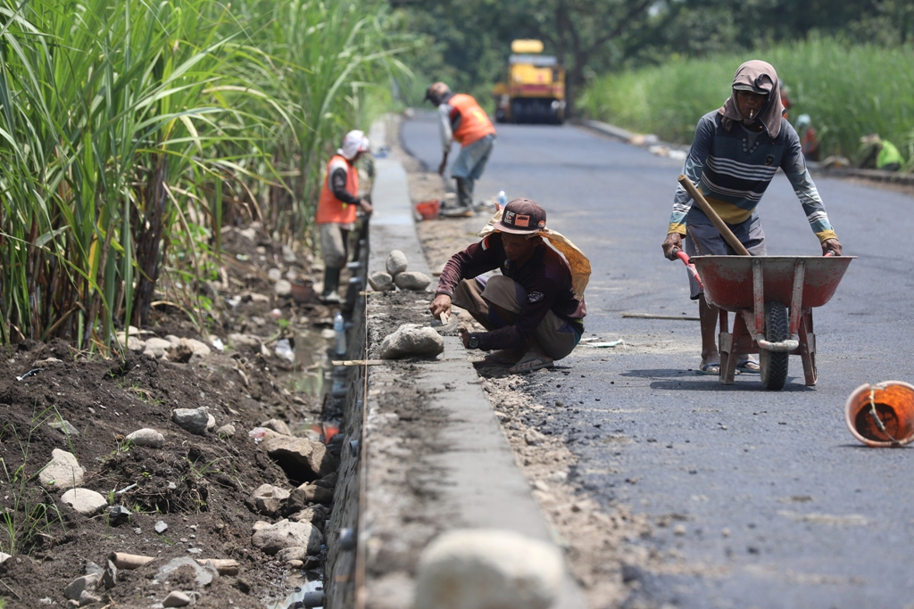 LEWATI TENGGAT: Pekerja menggarap proyek peningkatan jalan di Kelurahan Pulorejo, Kecamatan Prajurit Kulon, kemarin (29/12). Pekerjaan ini harusnya tuntas sejak Sabtu (27/12) lalu.