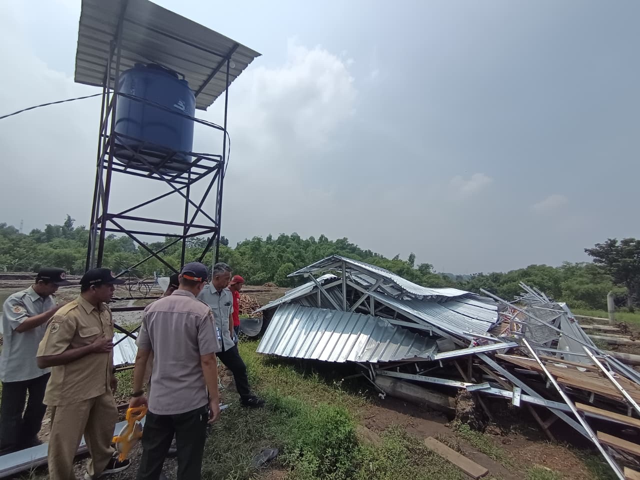 AMBRUK: Tim BPBD Kabupaten Mojokerto melakukan asesmen terhadap kondisi kandang ayam petelur yang luluh lantak diterjang angin kencang di Desa Payungrejo, Kecamatan Kutorejo, kemarin (29/12).