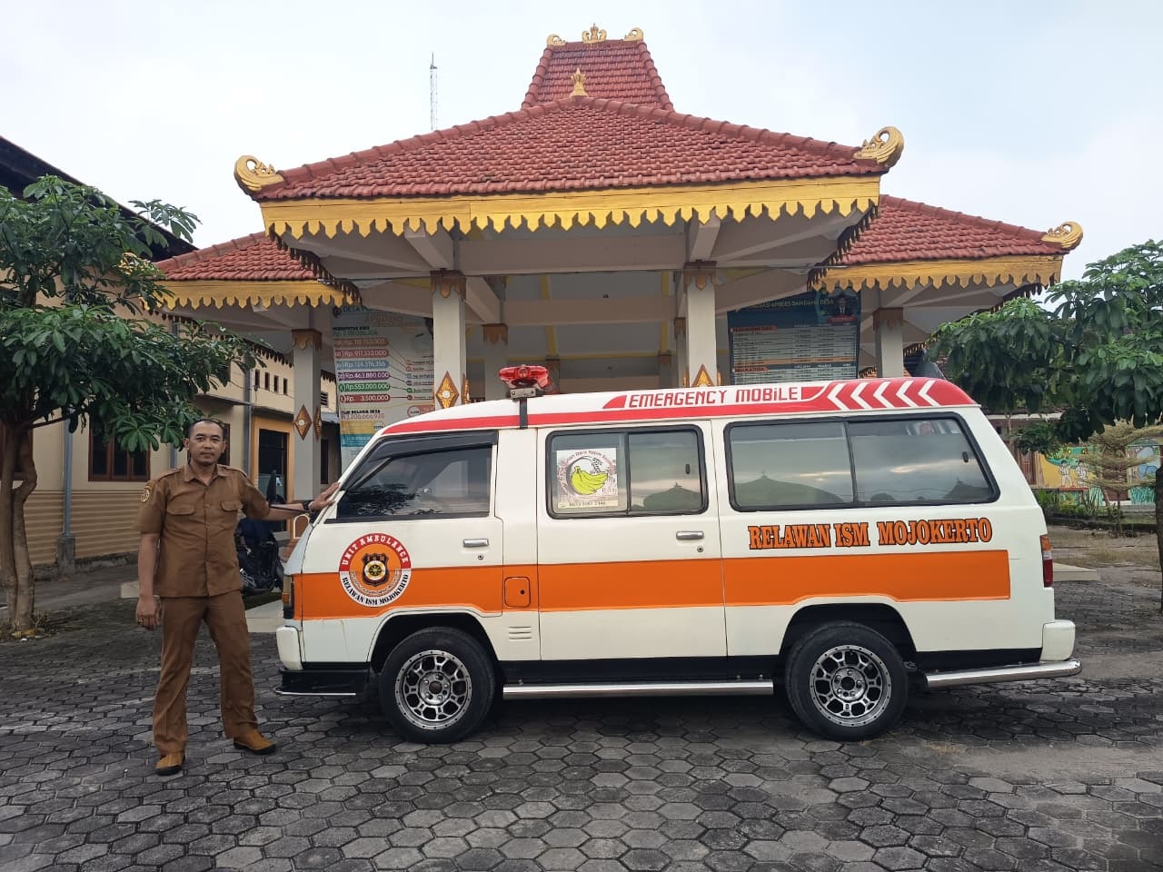 SIAP SIAGA: Kaur Kesra Pemdes Pohkecik Angga Febri Kurniawan bersama armada ambulans yang disiagakan di Balai Desa Pohkecik, Kecamatan Dlanggu.