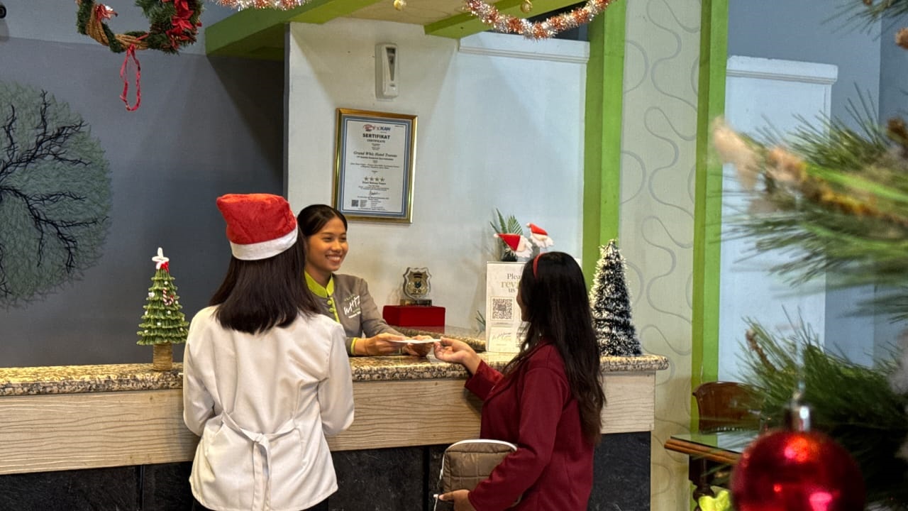 OKUPANSI TINGGI: Petugas Grand Whizz Hotel melayani pengunjung.