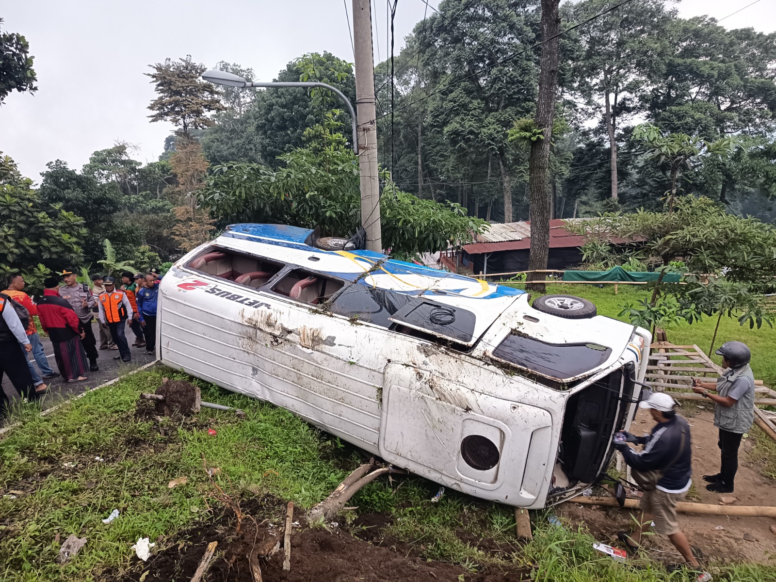 NAHAS: Kondisi mobil Isuzu Elf yang mengangkut rombongan wisatawan asal Surabaya terguling di jalur Pacet-Sendi akibat rem blong, Kamis (1/1).