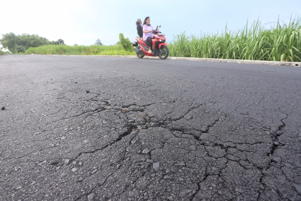 PECAH: Kondisi aspal jalan di lingkungan Kelurahan Pulorejo, Kecamatan Prajurit Kulon, yang rusak setelah sehari dibangun, Jumat (2/1).