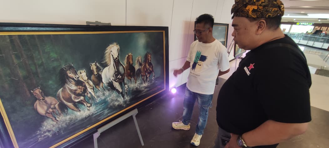 DIMINATI: Salah satu pengunjung tengah tawar menawar harga lukisan kuda yang menjadi salah satu karya primadona Diak Eko di Sunrise Mall 2 Mojokerto.