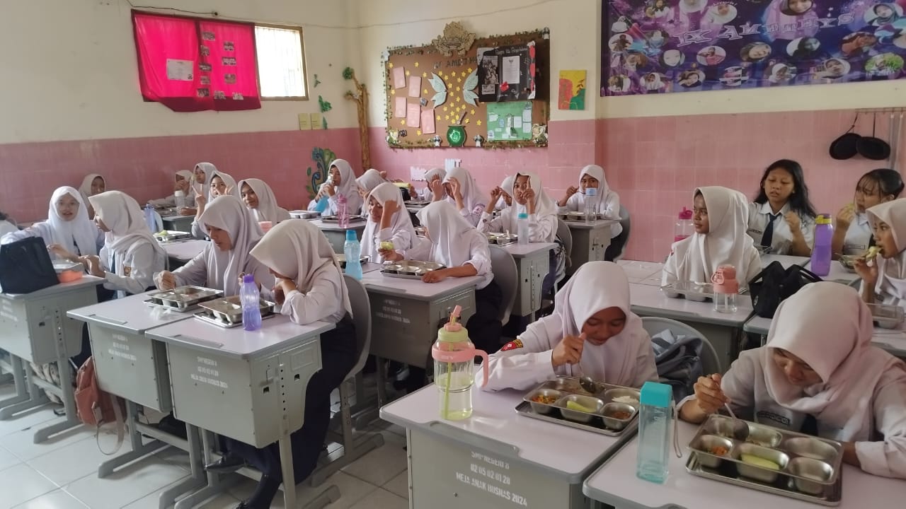 DIBERHENTIKAN: Siswa SMPN 8 Mojokerto saat menikmati MBG yang dibagikan beberapa waktu lalu. Awal Januari ini, operasional SPPG di kota diinstruksikan mandek sementara.
