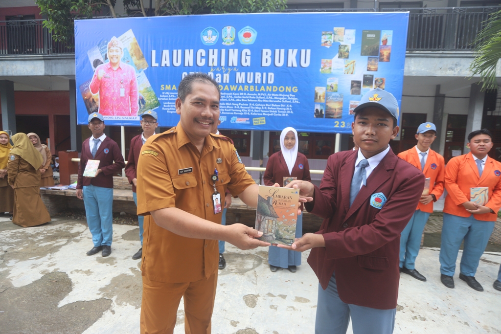 KREATIVITAS: Kepala SMAN 1 Dawarblandong Edy Sucahyono secara simbolis menyerahkan buku karya siswa sebagai tanda di-launching-nya karya antologi tersebut, kemarin (5/1).