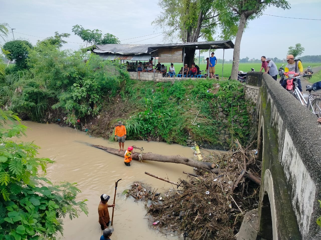 SUMBAT ALIRAN: Relawan mengevakuasi material yang menyumbat di sungai Dusun Patung, Desa/Kecamatan Pungging, kemarin (4/1)