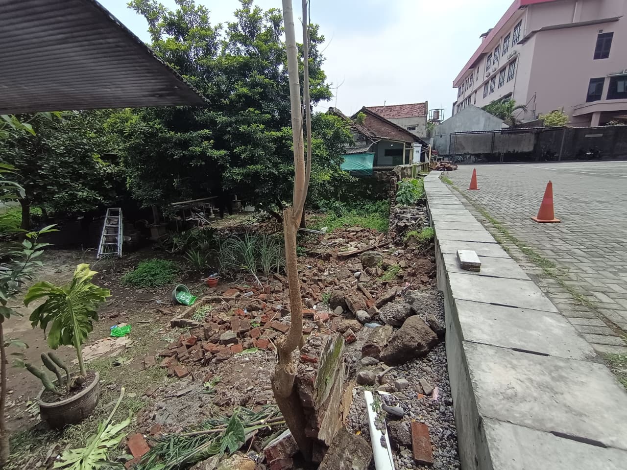 DINDING PEMBATAS: Tembok pagar rumah warga di Kelurahan Mojosari yang berbatasan dengan RSUD Prof. dr. Soekandar yang roboh saat hujan deras pada Sabtu, (3/1).