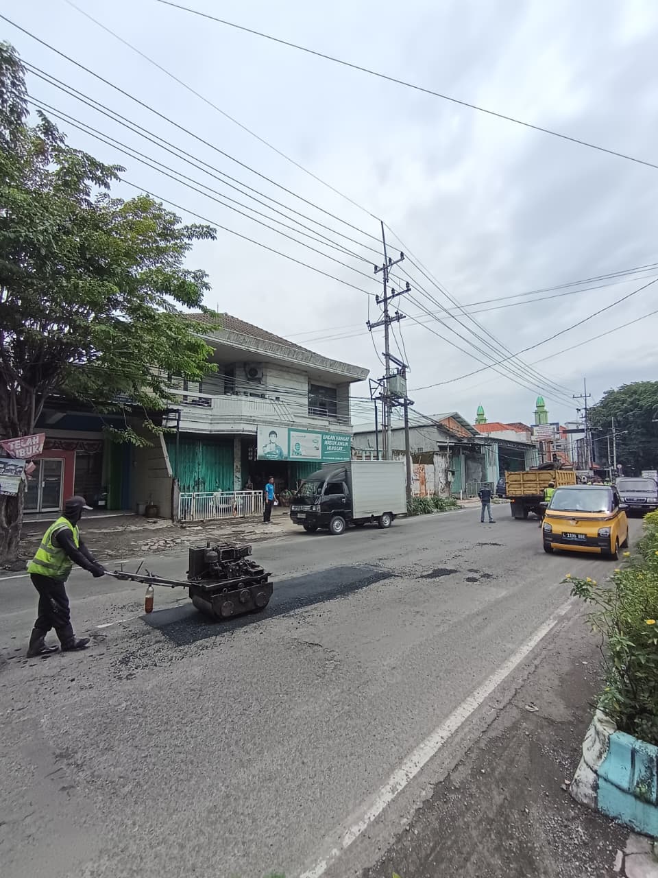 DIPERBAIKI: Jalur nasional di ruas Jalan Hayam Wuruk, Kecamatan Mojosari, Kabupaten Mojokerto dilakukan pengaspalan ulang di titik yang berlubang dan rusak, Selasa (5/1).
