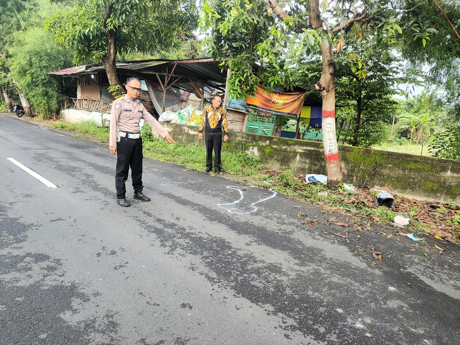 PENANGANAN: Petugas menunjukkan lokasi kecelakaan maut di Jalan Mayjen Sungkono, Kelurahan Wates, Kecamatan Magersari, usai melakukan olah TKP, kemarin (5/1).