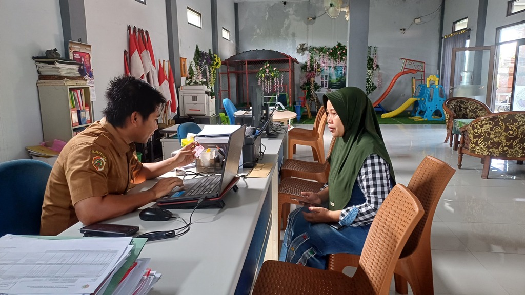 RESPONSIF: Kasi Pemerintahan Desa Ngrowo Fakhrul Nasrulloh sedang melayani warga dalam pembuatan KK dan akta kelahiran.