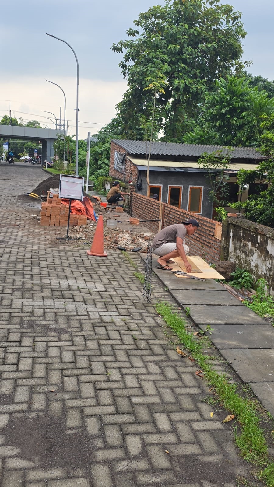 DIREHABILITASI: Pagar rumah warga yang berbatasan dengan RSUD Prof. dr. Soekandar, Kelurahan/Kecamatan Mojosari, Kabupaten Mojokerto, diperbaiki setelah roboh akibat terdampak luapan arus saluran air