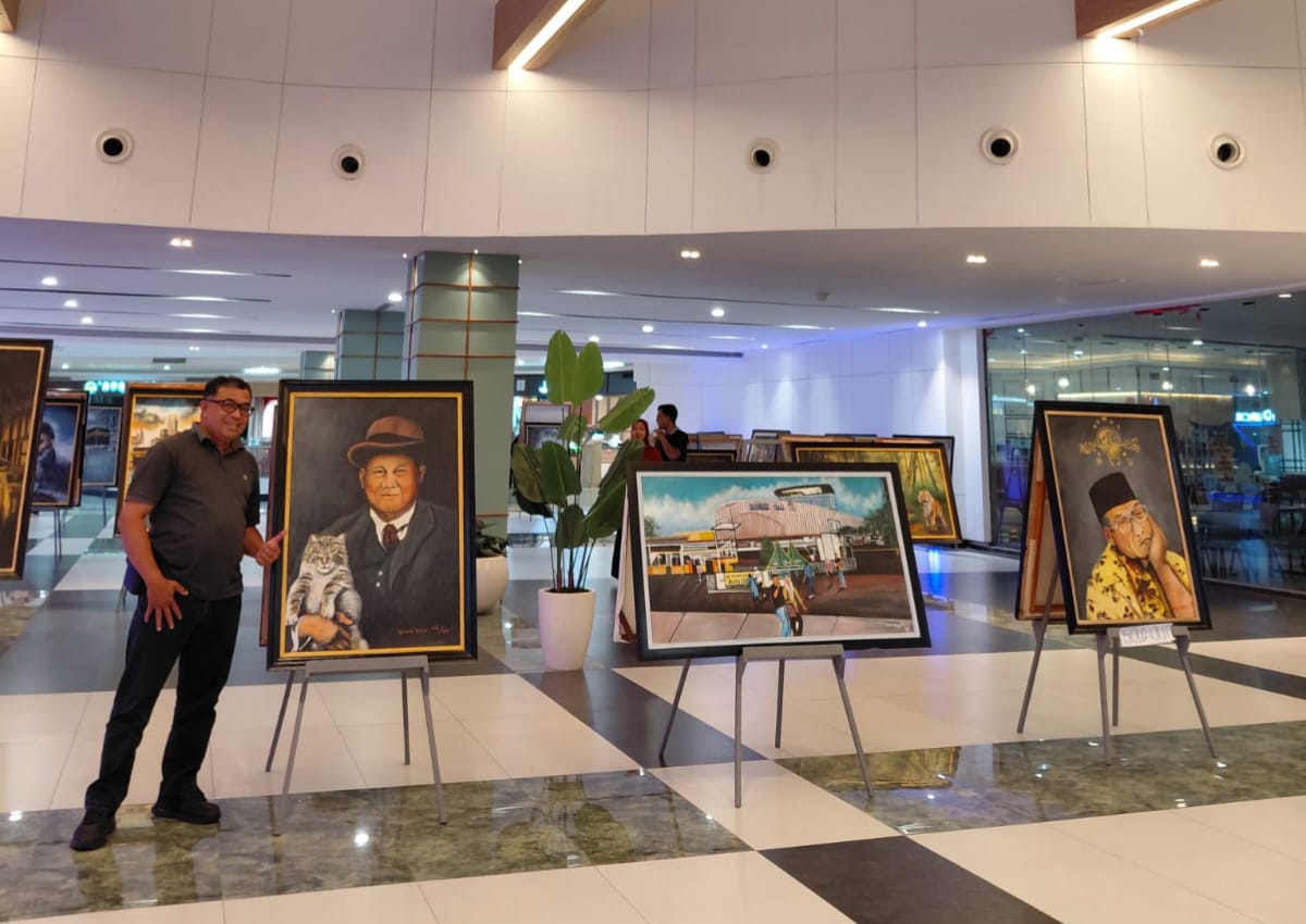 MENILIK KARYA: Kepala Stasiun Transmisi Digital SCTV-Indosiar Surabaya Paulus Budi Sujanto mampir berkunjung menikmati puluhan karya lukis Diak Eko di Sunrise Mall 2 Mojokerto, Kamis (8/1).