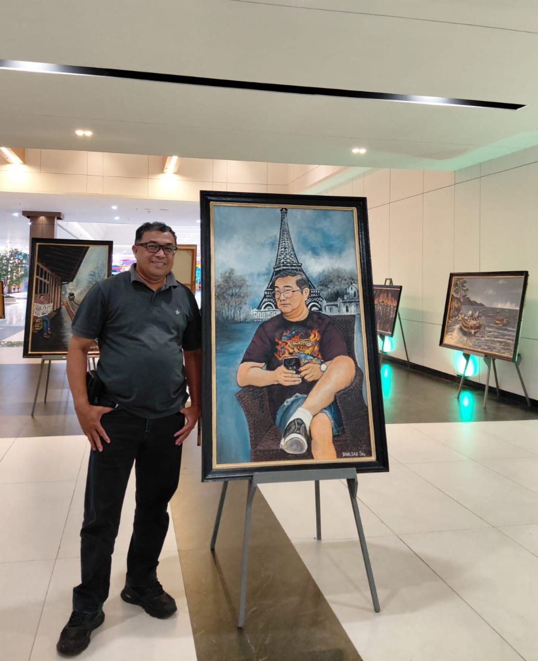 MENILIK KARYA: Kepala Stasiun Transmisi Digital SCTV-Indosiar Surabaya Paulus Budi Sujanto mampir berkunjung menikmati puluhan karya lukis Diak Eko di Sunrise Mall 2 Mojokerto, Kamis (8/1).