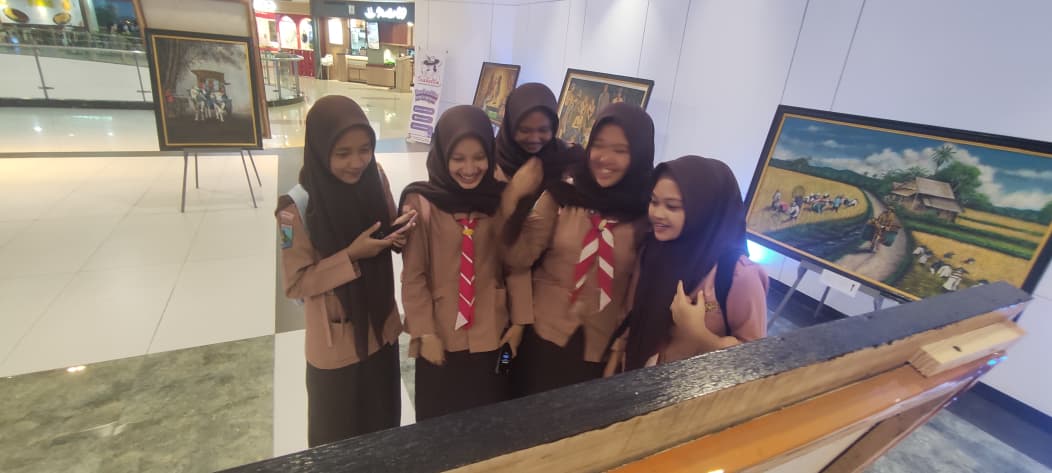 MENARIK PERHATIAN: Siswa SMKN 2 Mojokerto mengabadikan foto di beberapa lukisan yang mereka nilai menarik, kemarin (9/1).