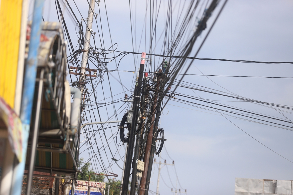 ILEGAL: Sejumlah tiang dan kabel FO di sejumlah ruas jalan di Kabupaten Mojokerto memanfaatkan rumija tanpa izin dan berimbas terhadap potensi kebocoran PAD.