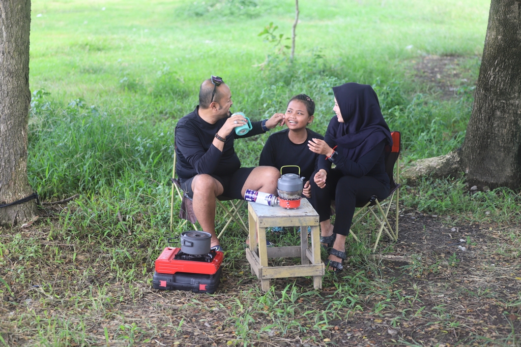 MOMEN SANTAI: Najib Al Falaq bersama anak dan istrinya menghabiskan akhir pekan di bantaran Sungai Brantas, Desa Mlirip, Kecamatan Jetis, kemarin (10/1).