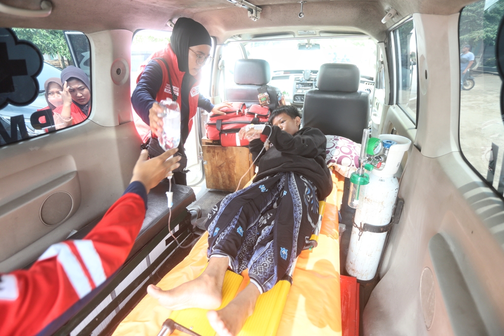 DIRUJUK KE RUMAH SAKIT: Petugas PMI Kabupaten Mojokerto mengevakuasi santri sekaligus siswa korban keracunan massal diduga usai konsumsi menu MBG di Ponpes Mahad An Nur, Desa Singowangi, Kecamatan Kut