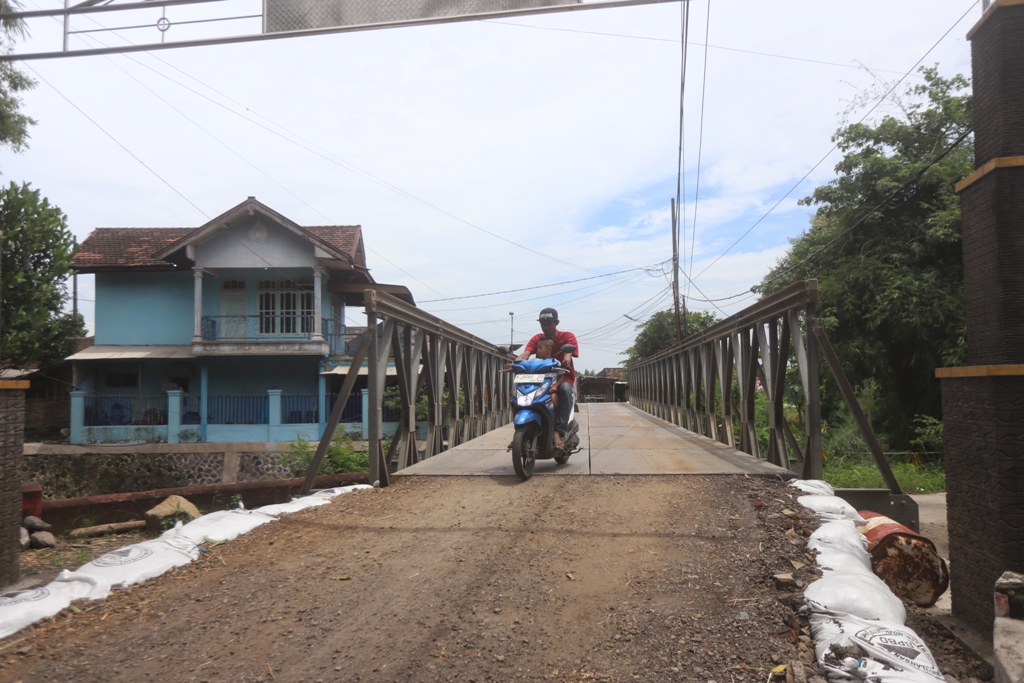 TERSAMBUNG: Jembatan bailey yang digunakan sebagai akses sementara untuk melintas di atas sungai Desa Wonodadi, Kecamatan Kutorejo, Kabupaten Mojokerto pasca jembatan utama terputus akibat diterjang a