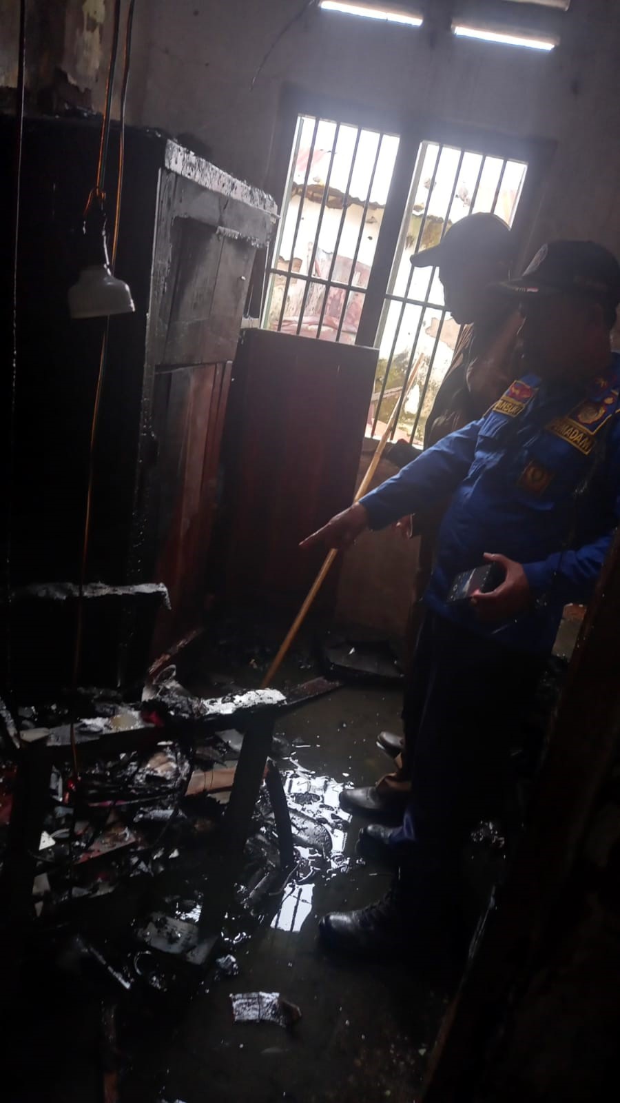 TITIK API: Petugas Damkar BPBD Kota Mojokerto menunjukkan lokasi titik api yang berada di kamar rumah warga yang terbakar, kemarin (12/1).