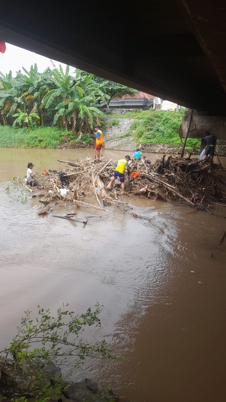 MANUAL: Petugas Bidang SDA Dinas PUPR Perakim Kota Mojokerto membersihkan tumpukan sampah di bawah Jembatan Murukan, kemarin (14/1).