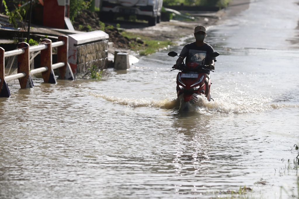 BUTUH SOLUSI: Seorang pemotor nekat menerjang banjir yang menerjang Jembatan Dusun Klanting, Desa Pulorejo, Kecamatan Dawarblandong, pekan lalu.