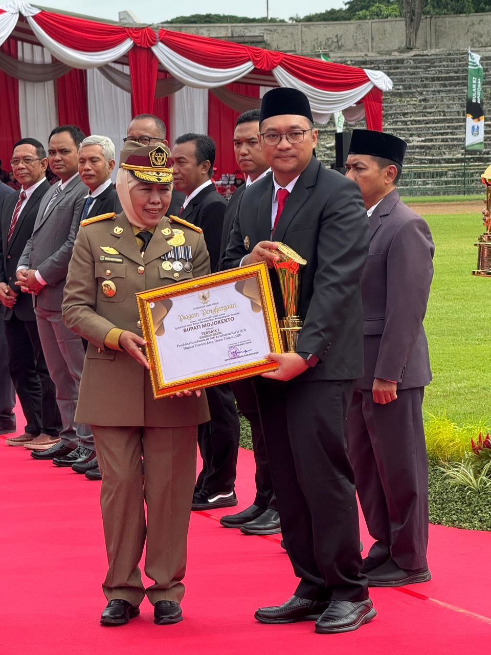 MEMBANGGAKAN: Gubernur Jatim Khofifah Indar Parawansa menyerahkan penghargaaan pada Wabup Mojokerto dr. M. Rizal Octavian pada Apel Peringatan Bulan K3 Nasional di Stadion Tri Dharma Petrokimia Gres