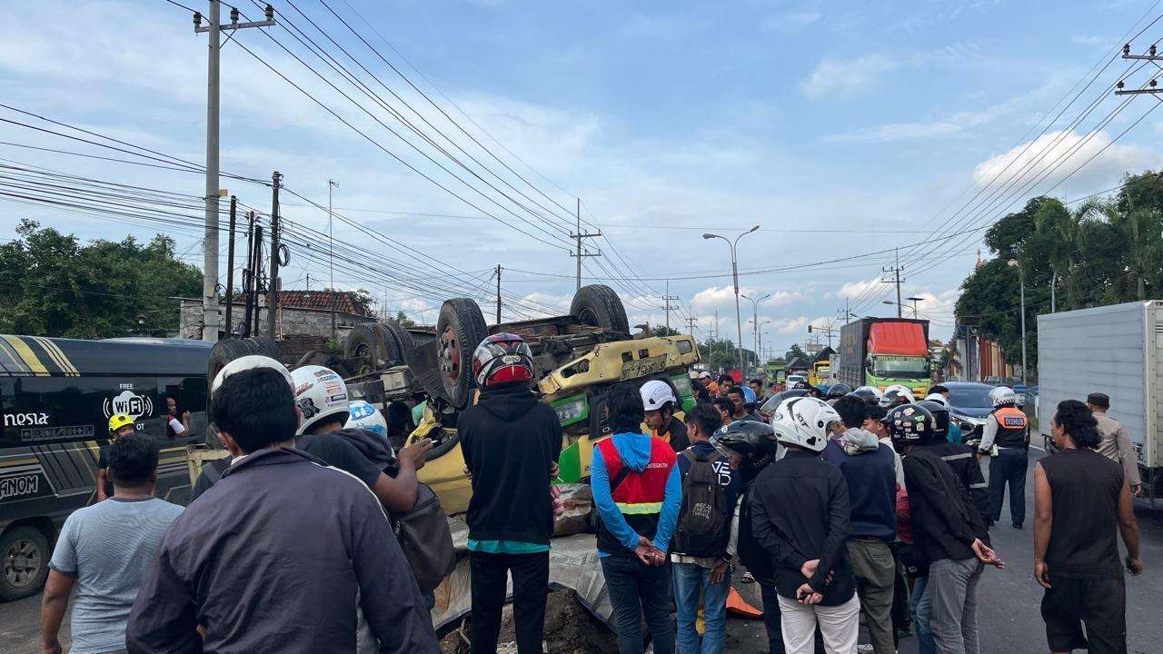 RINGSEK: Warga bersama petugas kepolisian mengevakuasi truk yang terbalik usai mengalami oleng saat melintas di jalur Arteri Mojokerto, tepatnya di Dusun Telogo Gede, Desa/Kecamatan Trowulan, Mojokert
