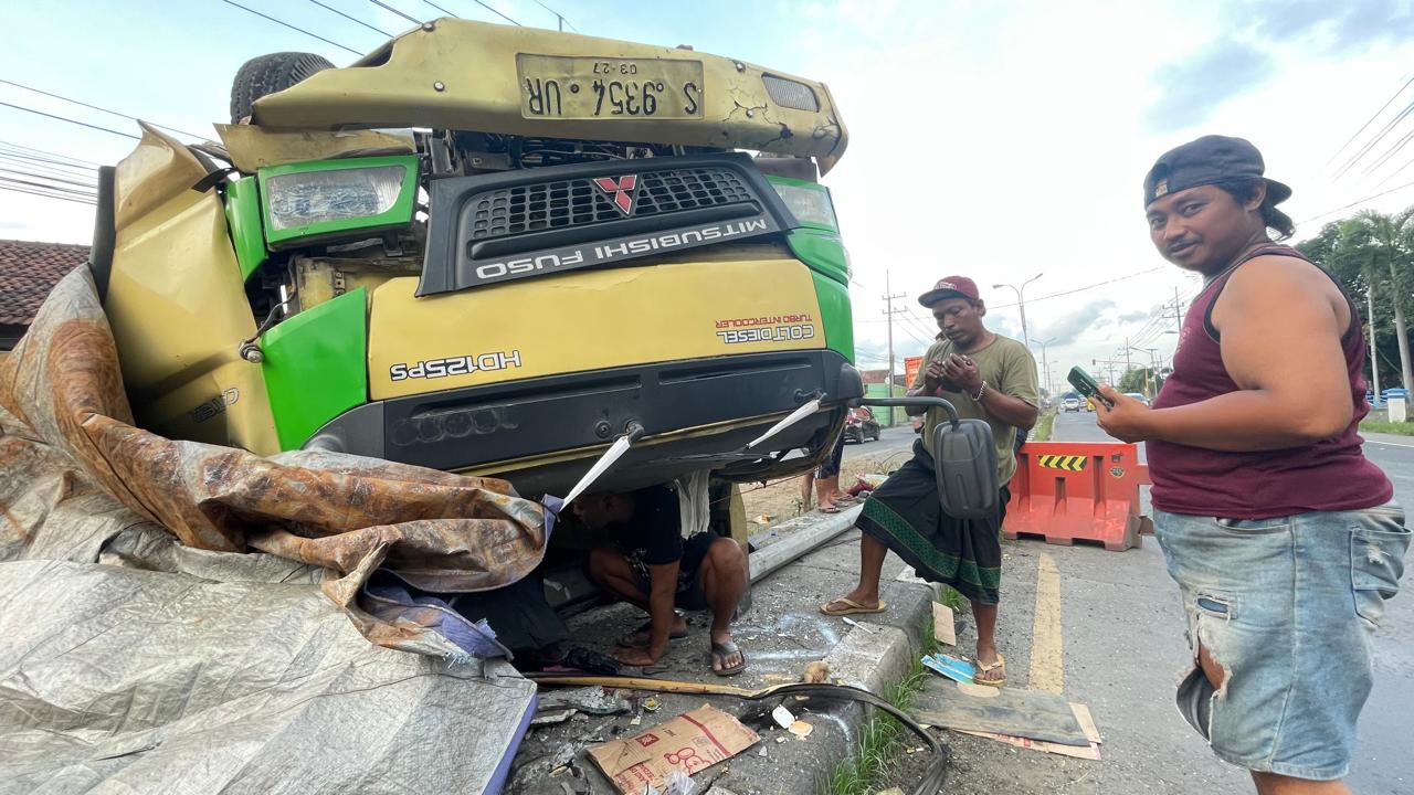 RINGSEK: Warga bersama petugas kepolisian mengevakuasi truk yang terbalik usai mengalami oleng saat melintas di jalur Arteri Mojokerto, tepatnya di Dusun Telogo Gede, Desa/Kecamatan Trowulan, Mojokert