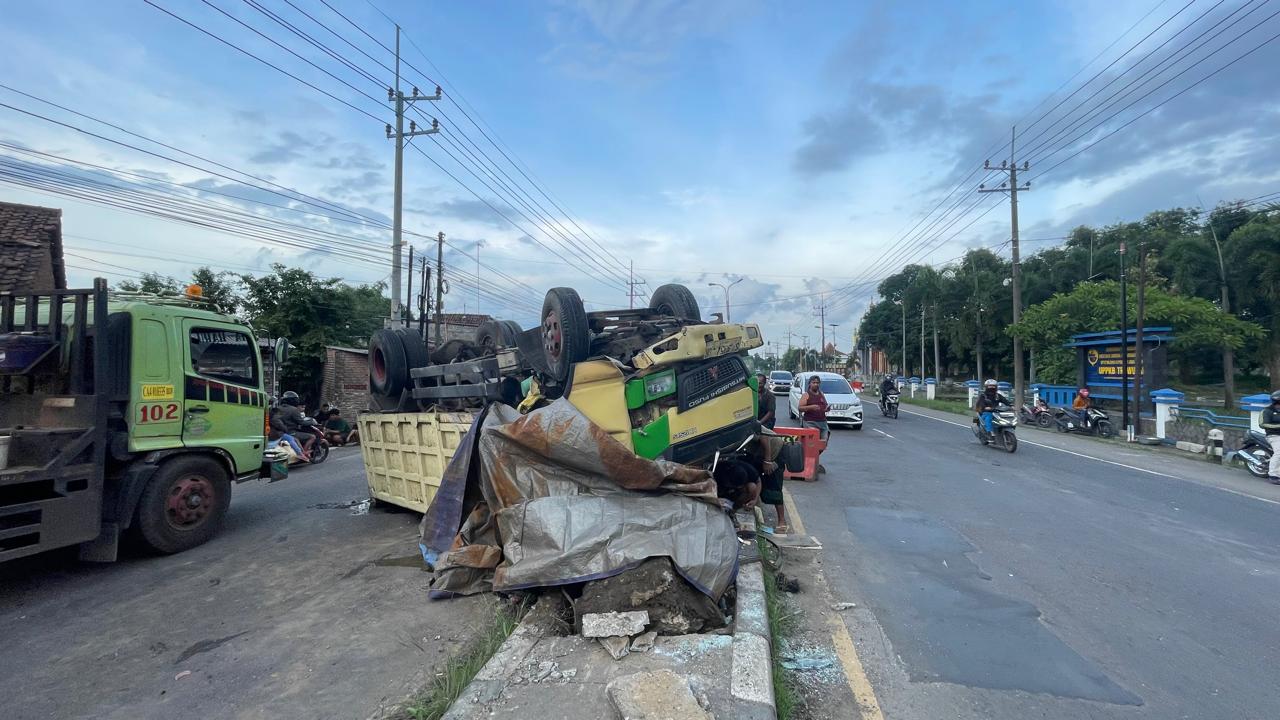 RINGSEK: Warga bersama petugas kepolisian mengevakuasi truk yang terbalik usai mengalami oleng saat melintas di jalur Arteri Mojokerto, tepatnya di Dusun Telogo Gede, Desa/Kecamatan Trowulan, Mojokert