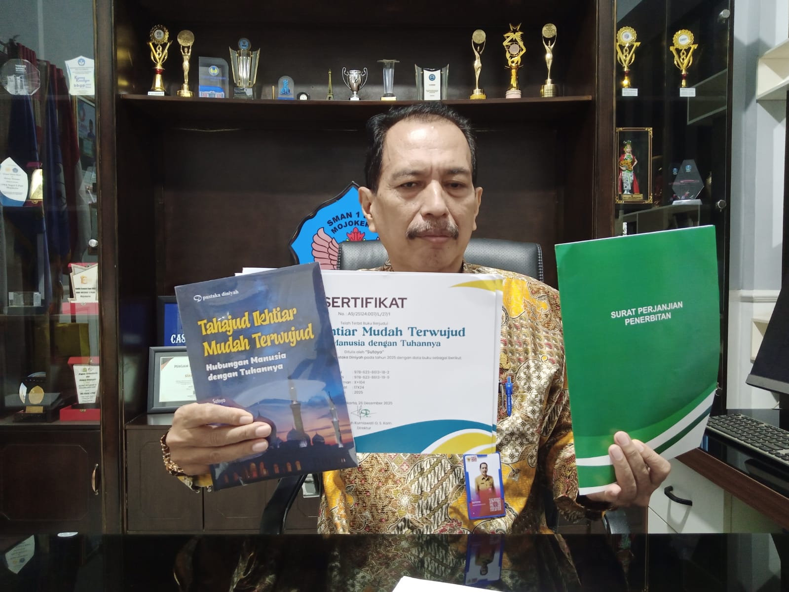 TERBARU: Kepala SMAN 1 Puri Sutoyo bersama buku kesembilan beserta MOu Royalti 25 tahun.