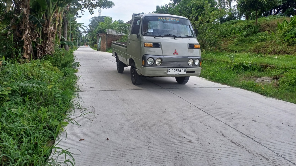 MULUS: Pengguna kendaraan roda empat melintasi jalan lingkungan rabat beton di Desa Tunggalpager, Kecamatan Pungging, yang telah selesai dibangun.