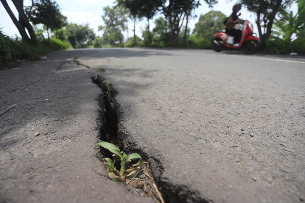 TERBELAH: Begini kondisi jalan aspal di jalan perbatasan antara Kota Mojokerto dengan Kabupaten Mojokerto, Kecamatan Prajurit Kulon