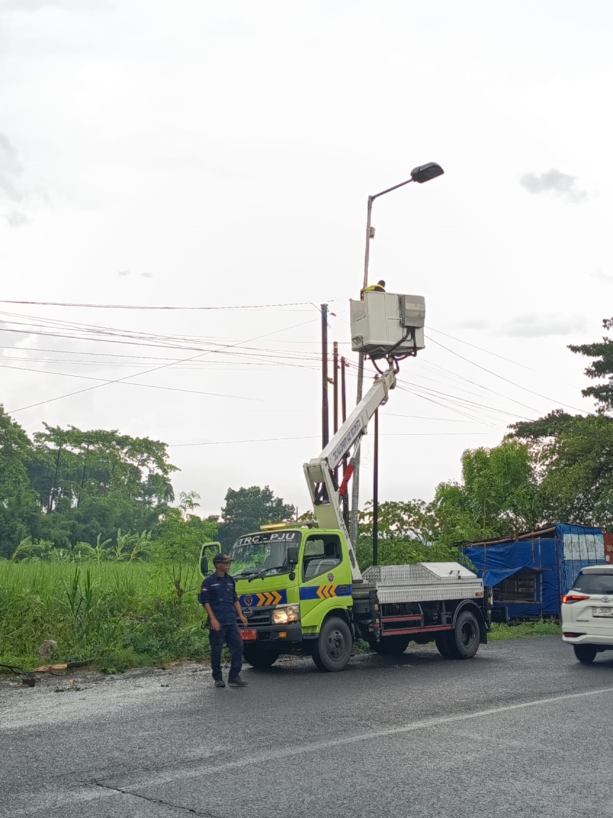 DIPERBAIKI: Petugas TRC DPRKP2 Kabupaten Mojokerto memperbaiki lampu PJU di ruas Jalan Raya Pungging-Trawas yang mengalami kerusakan.