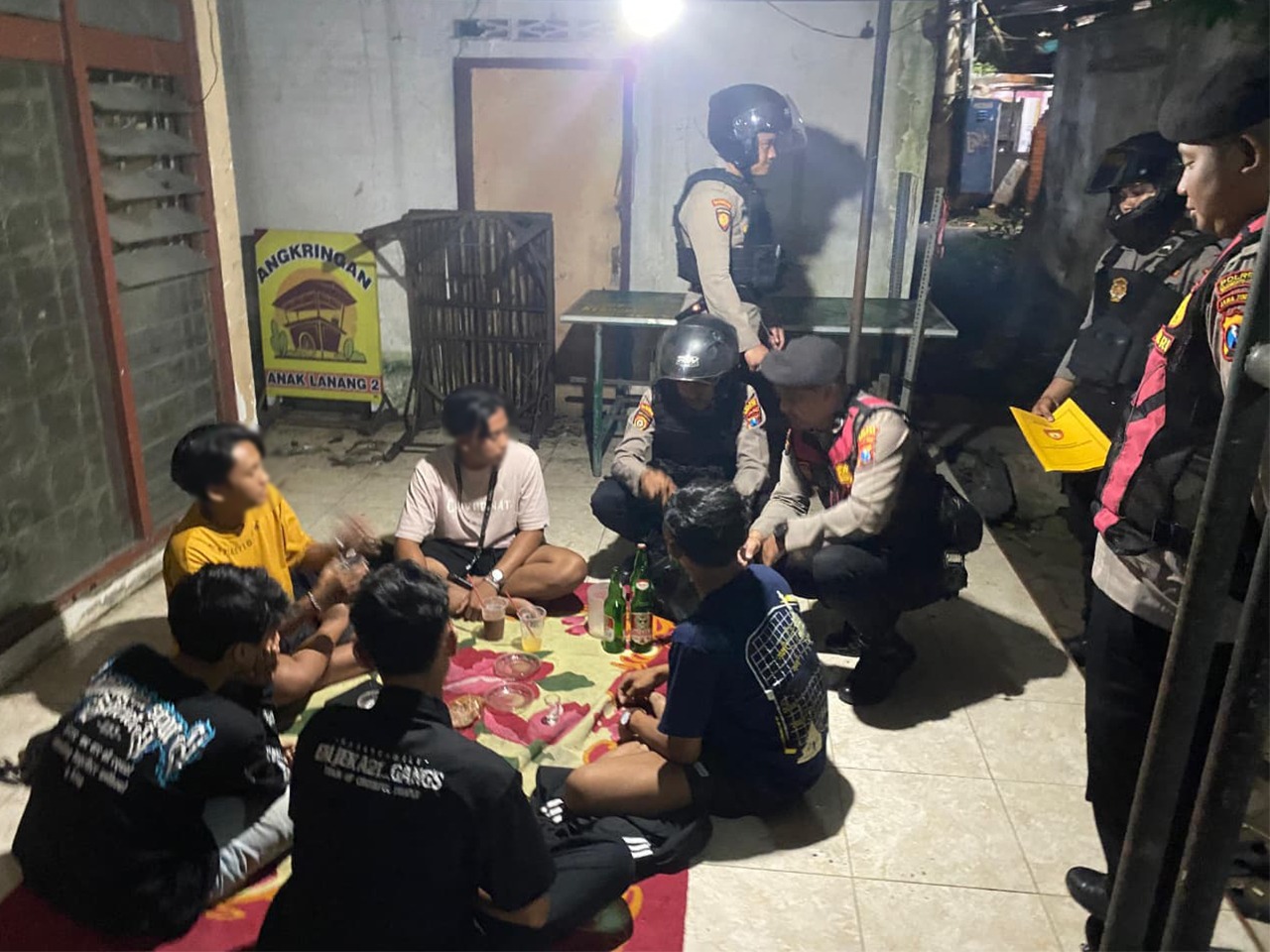 TEPERGOK: Personel Satsamapta Polres Mojokerto mengamankan sembilan pemuda yang nongkrong sambil menenggak miras, Kamis (22/1) malam.