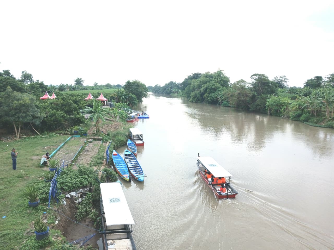 RAWAN MELUAS: Perahu wisata susur Sungai Ngotok di kawasan TBM, Kota Mojokerto, membawa wisatawan menuju dermaga di dekat tanggul yang longsor, kemarin (25/1).