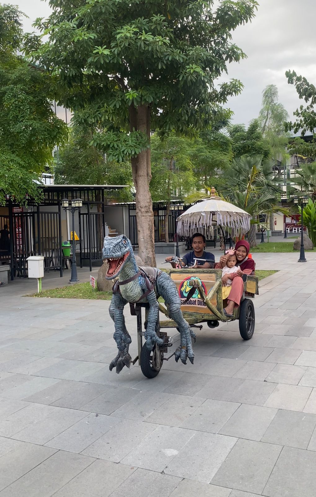 FAMILY TIMES: Satu keluarga pengunjung Pasar Semeru berkeliling menikmati area Taman Kuliner menggunakan wahana permainan dinosaurus genjot.