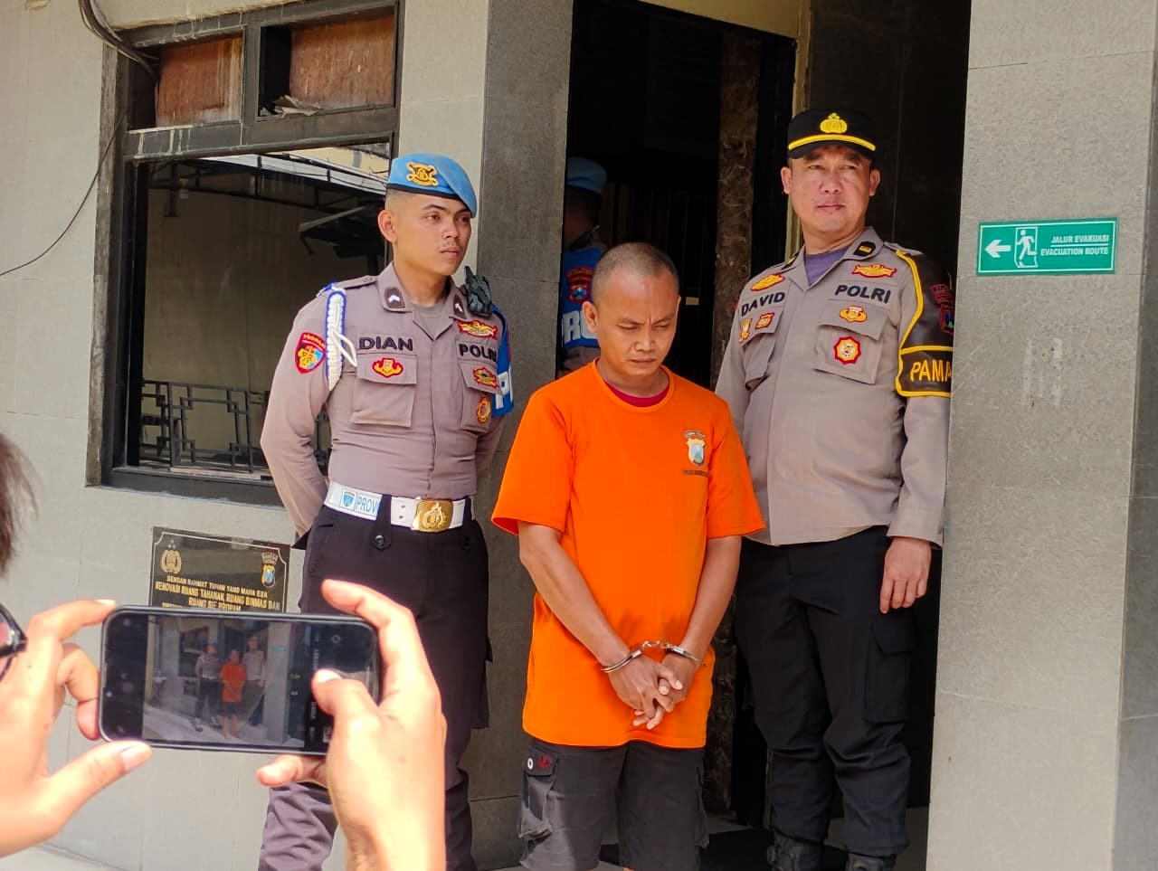 TAHANAN POLISI: Achmad Saiful dikeler petugas saat konferensi pers di Polres Mojokerto Kota, Desember lalu.