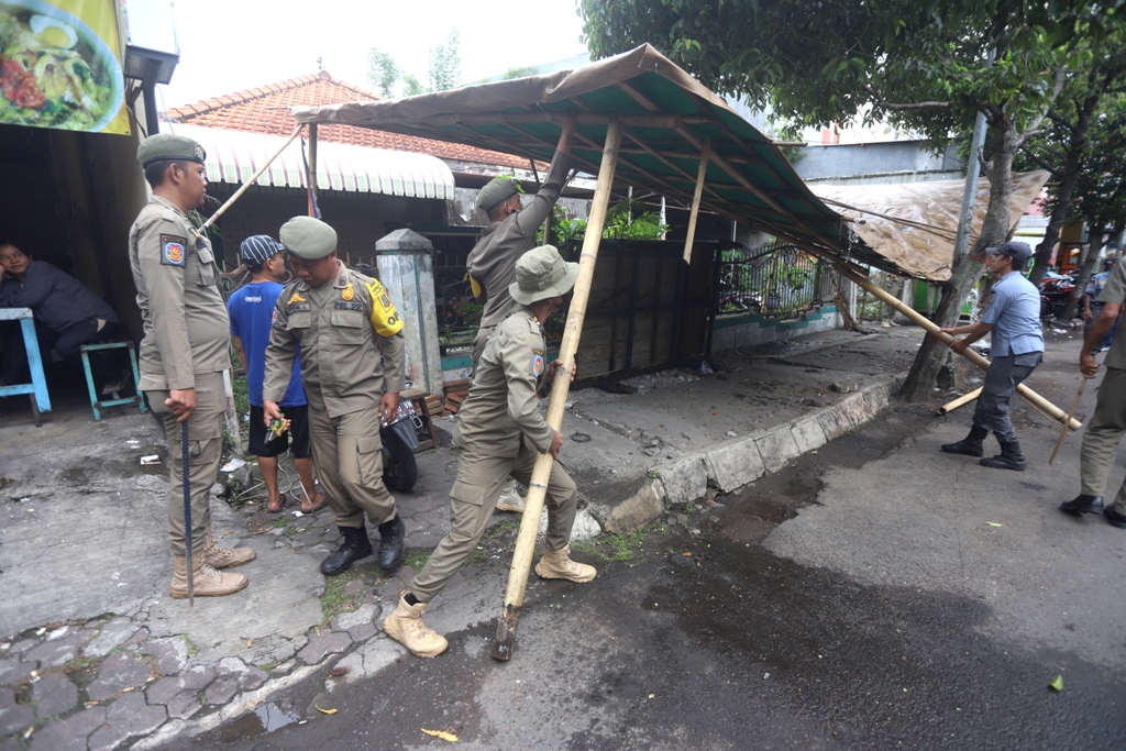 DIGARUK SATPOL: Petugas Satuan Polisi Pamong Praja Kota Mojokerto menertibkan pedagang kaki lima yang melanggar aturan di Jalan KH Nawawi, Kota Mojokerto, kemarin (27/1).