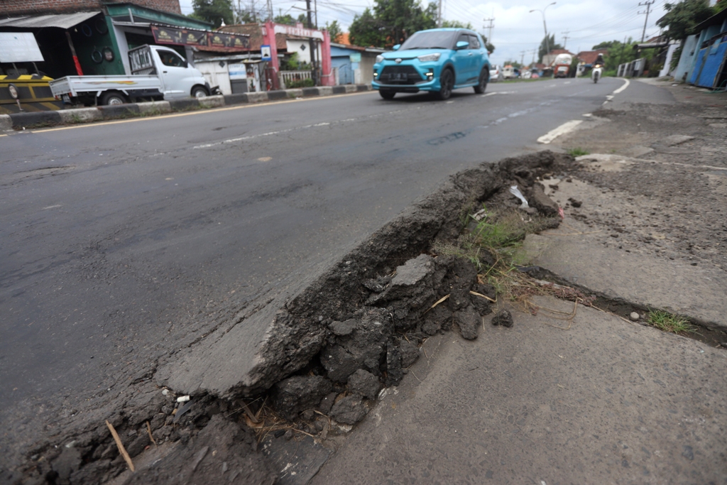 MEMBAHAYAKAN: Pengendara melintas di jalan nasional jalur bypass Desa Brangkal, Kecamatan Sooko, Kabupaten Mojokerto, kemarin (27/1). Di sepanjang wilayah Sooko hingga Trowulan banyak titik jalan dala