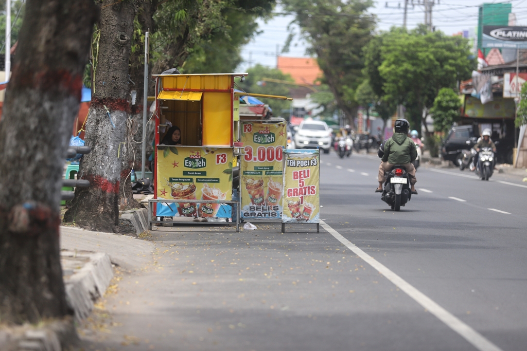 MENUNGGU PEMBELI: Pedagang minuman berjualan menggunakan booth container memanfaatkan bahu Jalan Surodinawan, Kelurahan Surodinawan, Kecamatan Prajurit Kulon, kemarin (28/1).