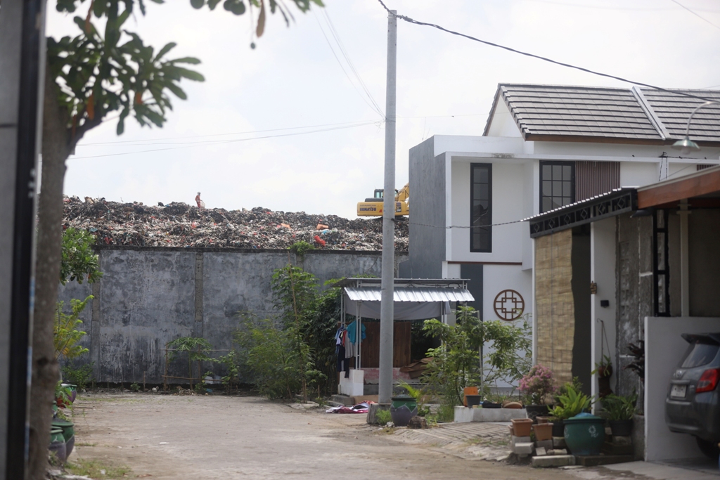 Gunungan sampah TPA Randegan Kota Mojokerto berhimpitan dengan tembok pemukiman, Jumat (30/1).