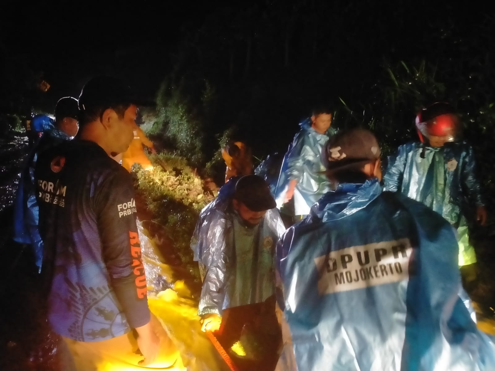 TERDAMPAK: BPBD Kabupaten Mojokerto bersama tim gabungan melakukan proses evakuasi material longsor di Jalan Pacet-Trawas, Desa Claket, Senin (2/2) malam.