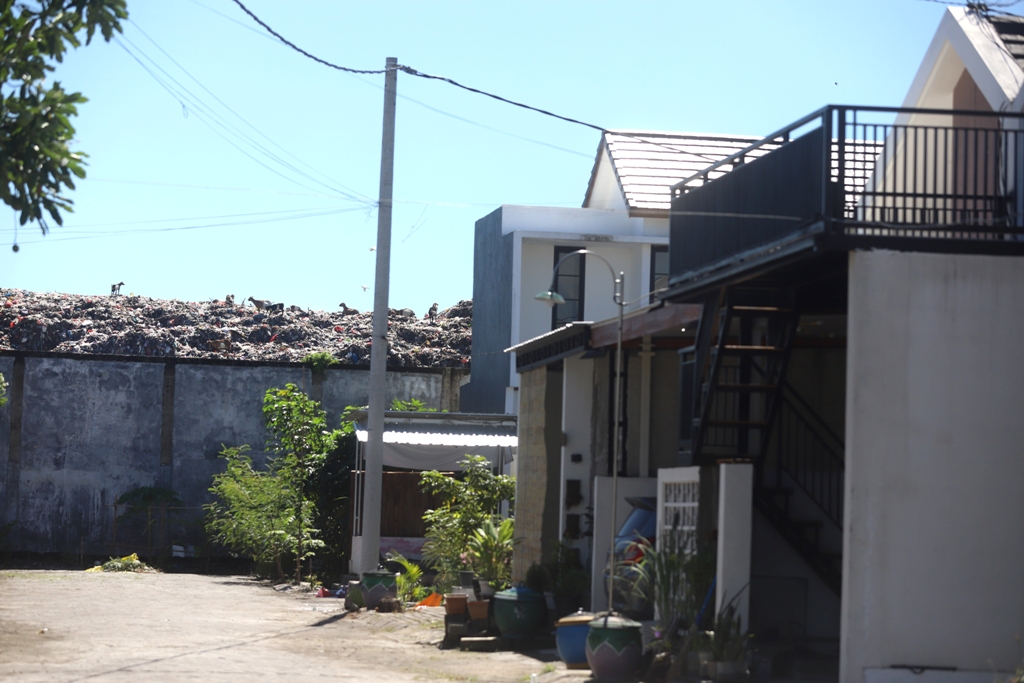 DIKELUHKAN: Sampah di TPA Randegan, Kota Mojokerto, berdekatan dengan tembok warga Perumahan The Suam Residence, Kelurahan Kedundung, Kecamatan Magersari, kemarin (3/2).