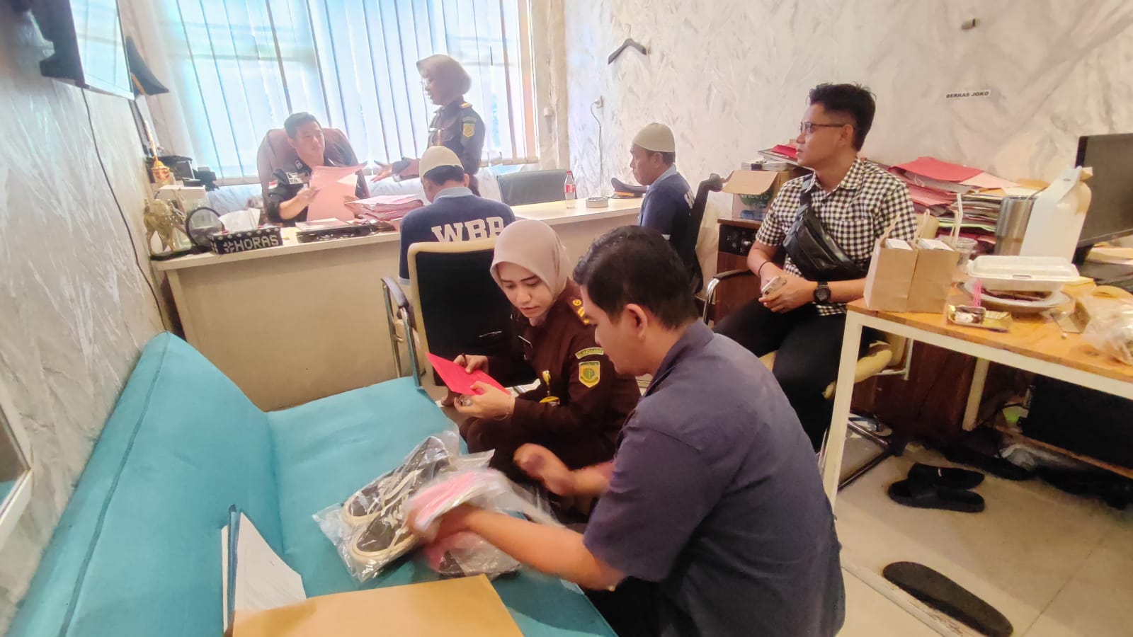 DISERAHKAN: Anggota Unit Reskrim Polsek Pacet melakukan tahap II penyerahan dua tersangka dan barang bukti kasus penipuan dan penggelapan ke Kejari Kabupaten Mojokerto, Selasa (3/2).
