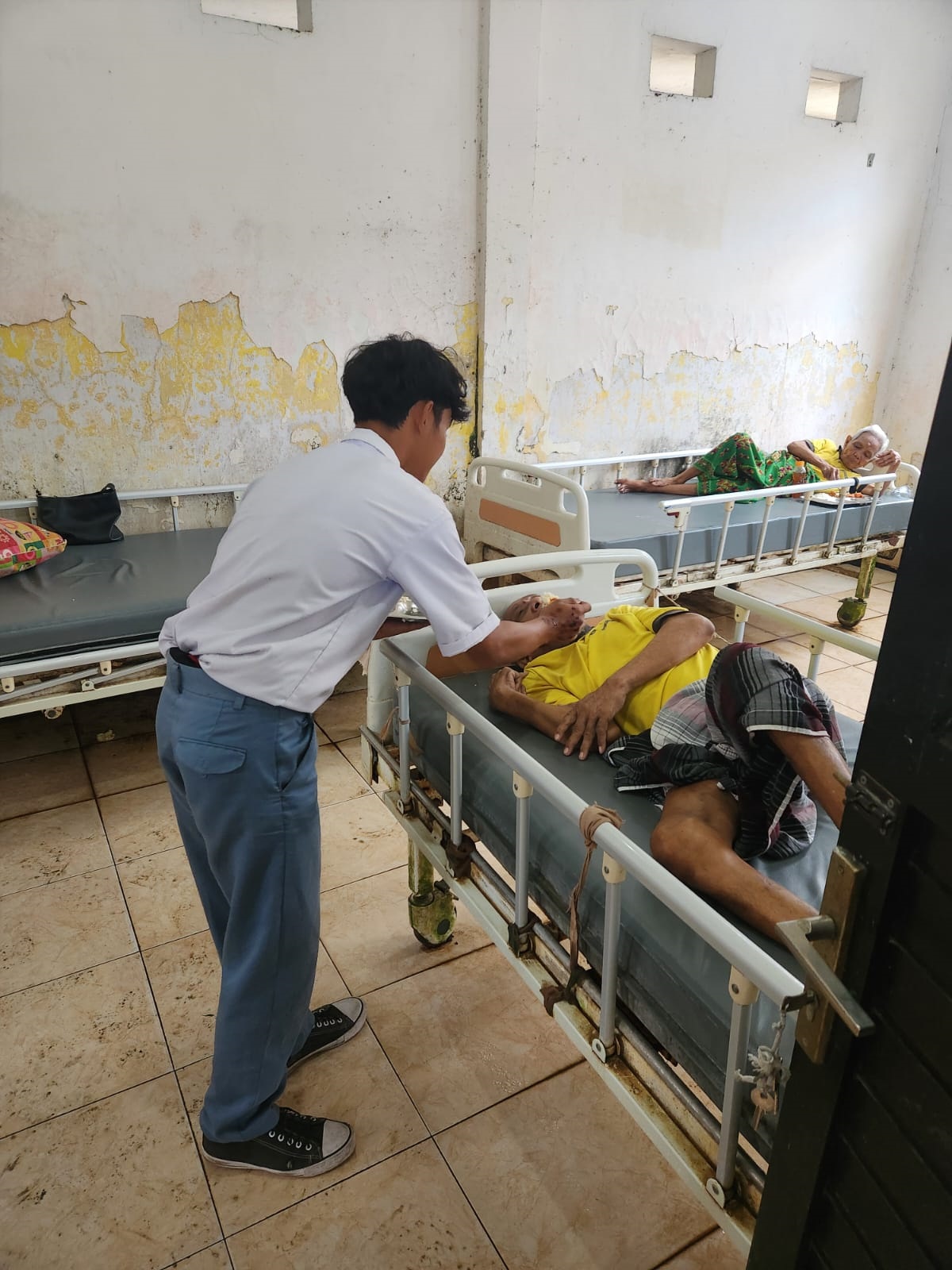 SANKSI SOSIAL: Salah satu pelajar merawat lansia penghuni Panti Werdha di UPT Pesanggrahan PMKS, Desa Kedungmaling, Kecamatan Sooko, Kabupaten Mojokerto.