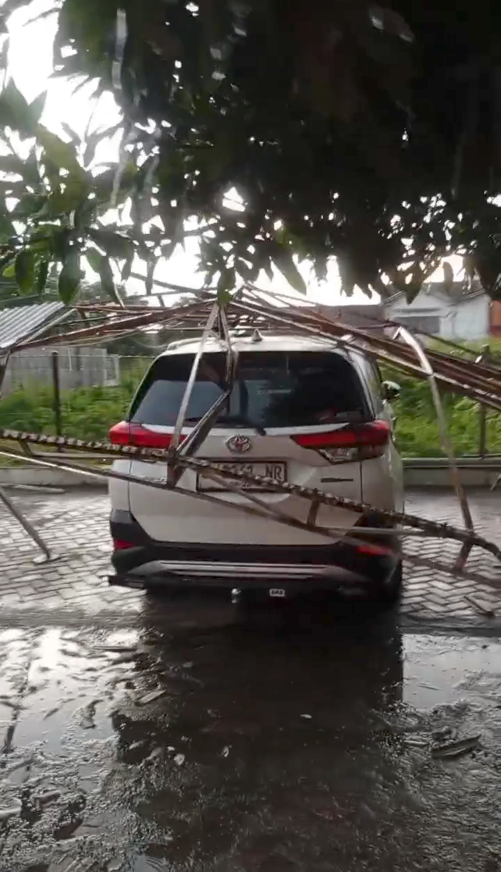 TERDAMPAK: Sebuah mobil Daihatsu Terios milik warga tertimpa atap parkiran Masjid Mujahidin yang ambruk dihempas angin, Rabu (5/2) petang.