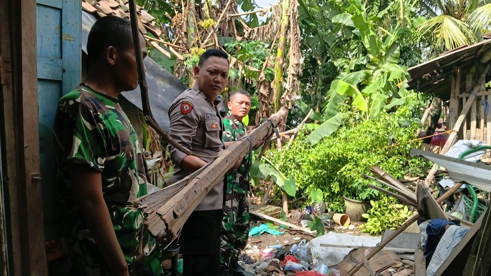 SUKARELA: Warga bersama TNI dan Polri gotong royong membersihkan rumah terdampak angin kencang di Desa Wringinrejo, Kecamatan Sooko, kemarin (5/2).