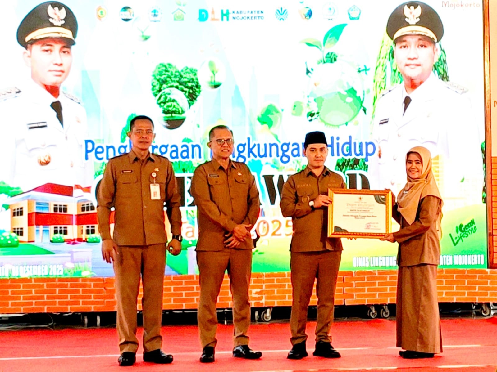 LUAR BIASA: Kepala SMPN 3 Kutorejo Khusnul Mudawamah menerima penghargaan Adiwiyata tingkat provinsi dari Bupati Mojokerto Muhammad Albarraa.