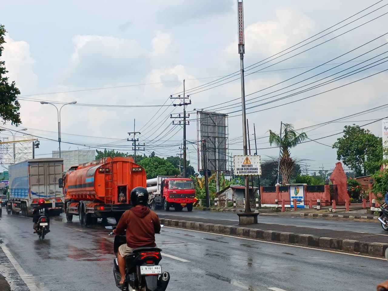 RAWAN KECELAKAAN: Rambu peringatan jalan berlubang dan bergelombang terpasang di jalan nasional Bypass Desa Jampirogo, Kecamatan Sooko, Kabupaten Mojokerto, kemarin (7/2).