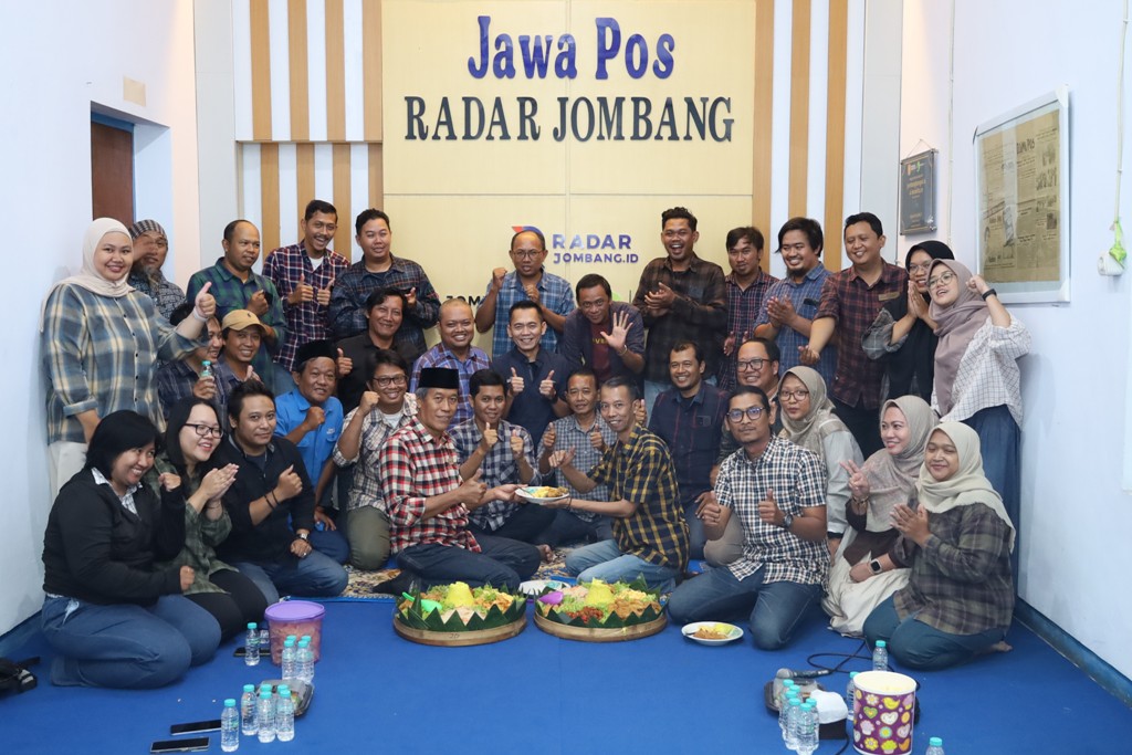 BERSYUKUR: Direktur JPRM M. Nur Kholis menyerahkan potongan tumpeng kepada Pemimpin Redaksi JPRM Moch. Chariris saat tasyakuran Hari Pers Nasional 2026 di kantor Jawa Pos Radar Jombang, Senin (9/2).